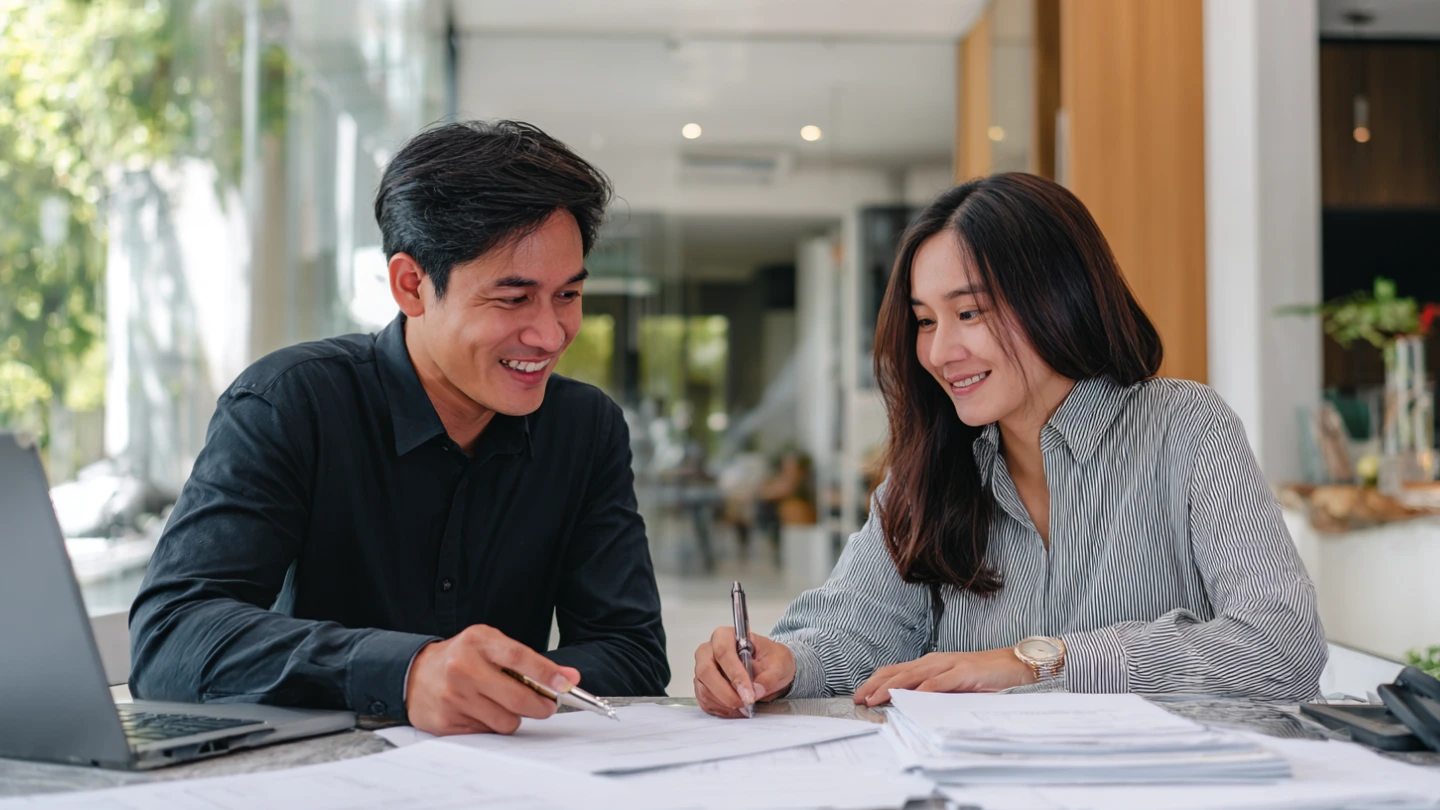 Homeowner and contractor reviewing renovation contract documents together in Kuala Lumpur meeting Homeowner and contractor reviewing renovation contract documents together in Kuala Lumpur meeting